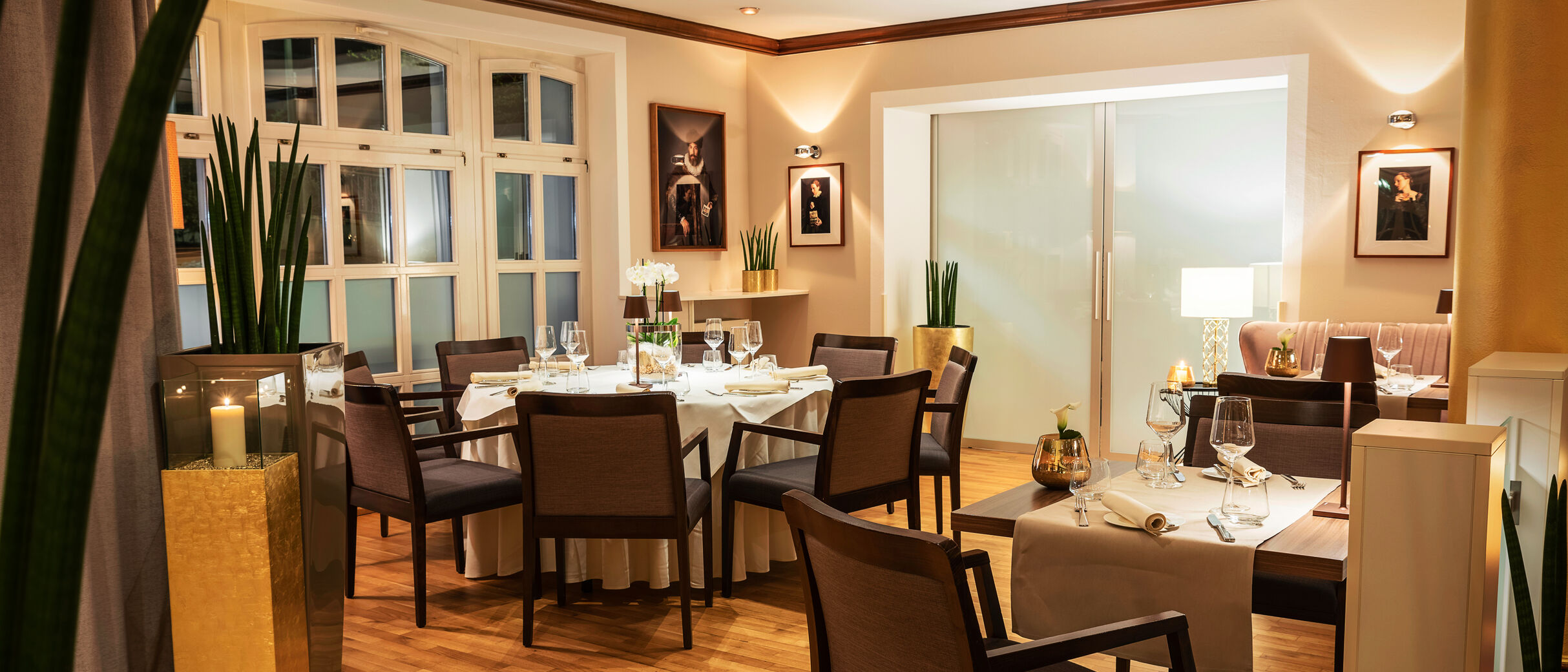 Empore im Restaurant mit rundem Tisch, sanftes Licht verstärkt die gemütliche, elegante Atmosphäre.