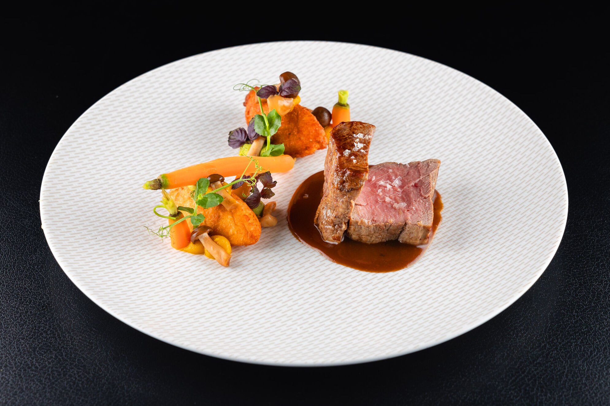 Beef fillet on a sauce mirror, with carrots on the side.