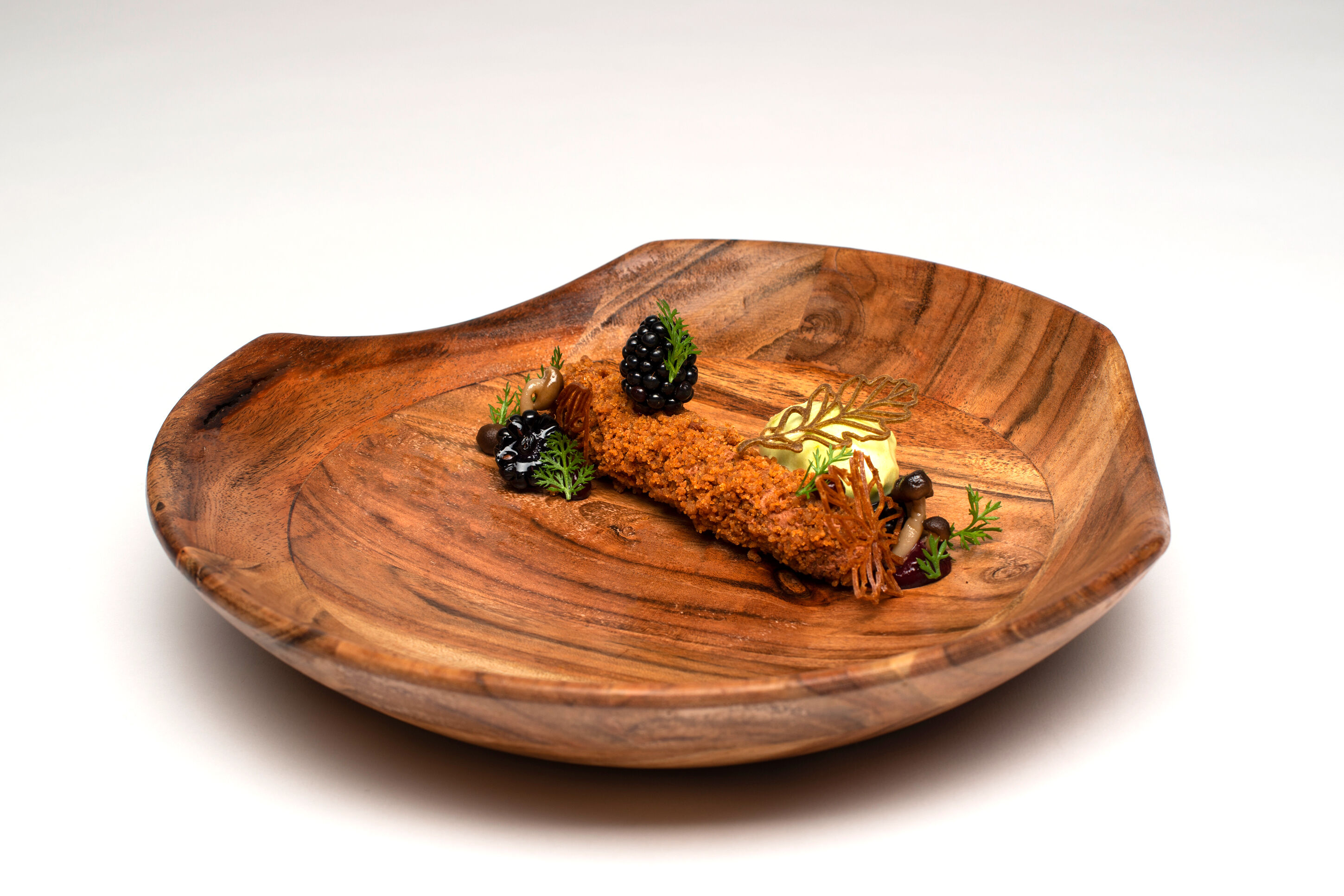Dessert aus Valrhona-Schokolade und frischen Brombeeren, serviert auf rustikalem Holz-Teller.