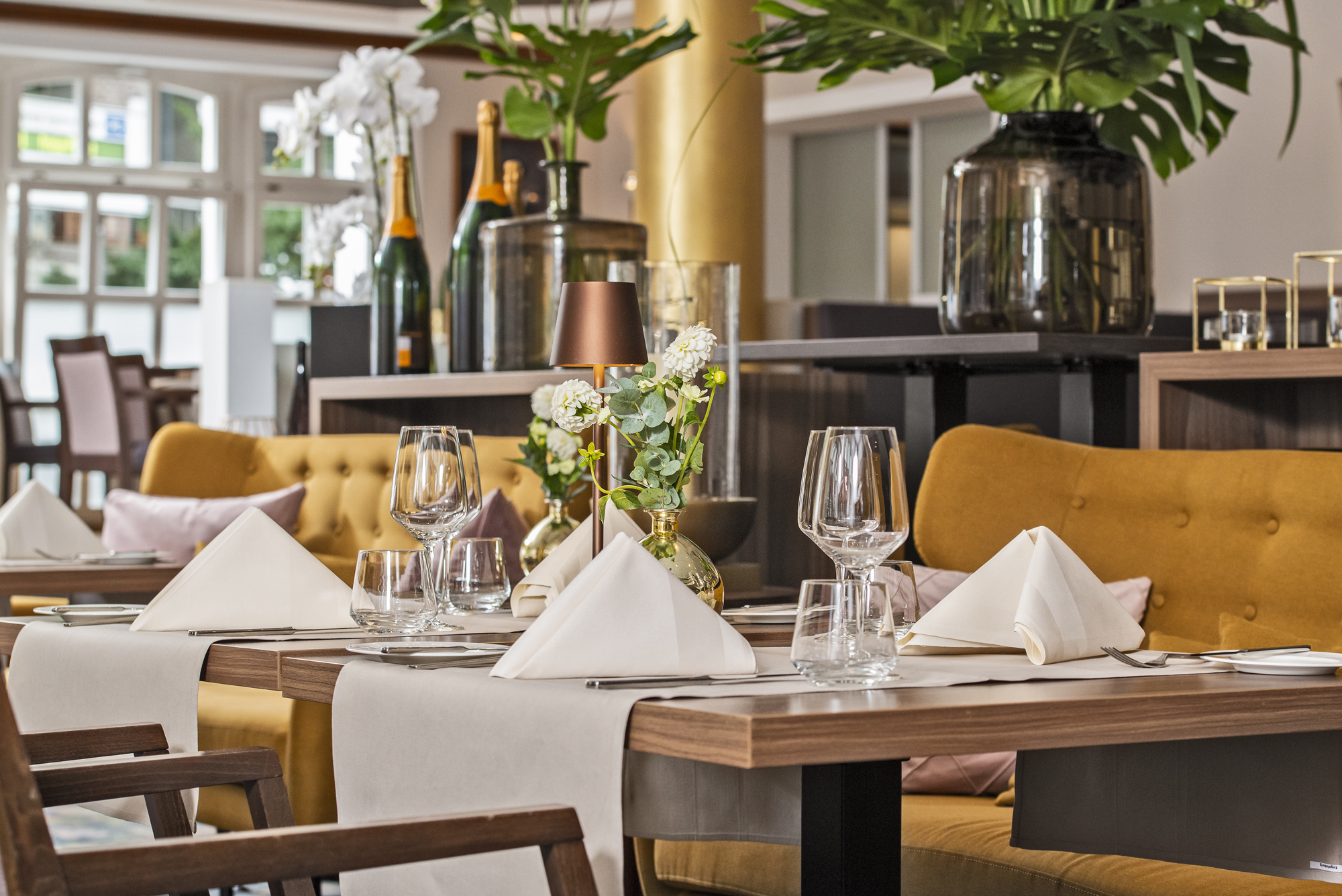 Innenaufnahme des Restaurants Engels in der Burg in Recklinghausen. Stilvoll gedeckte Tische mit goldenen Akzenten schaffen ein elegantes und einladendes Ambiente.
