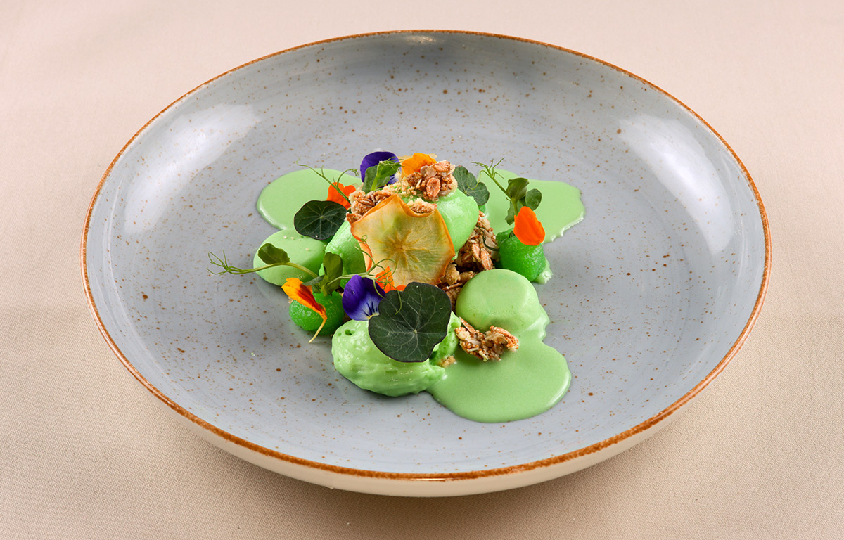 Kunstvoll angerichtetes grünes Dessert mit Sauerampfer, Apfel, Cremeux, Espuma und Krokant.